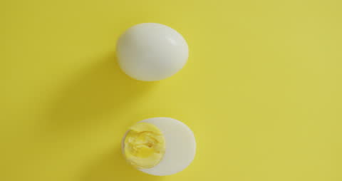 Minimalist Display of Hard Boiled Egg on Vibrant Yellow Background