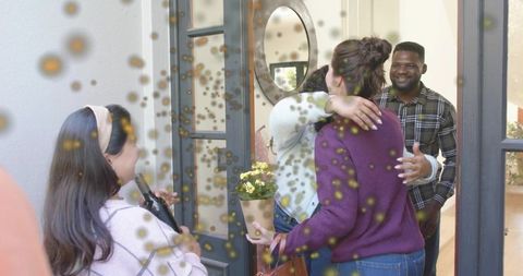 Friends Hugging at Doorway with Confetti and Potted Plant Gift | Warm Welcome Reunion