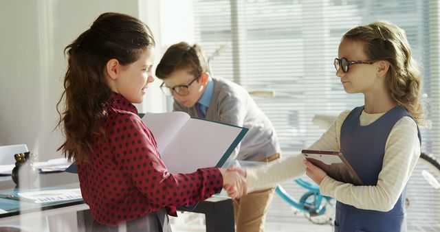 Children Acting Out Business Scenario with Shaking Hands and Paperwork - Download Free Stock Images Pikwizard.com