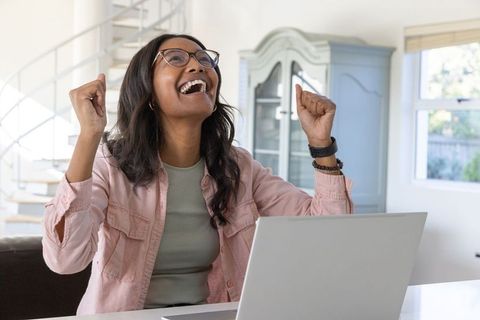 Celebrating Success at Home Office with Laptop