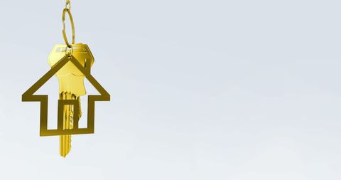 Golden key with house keychain on minimal background