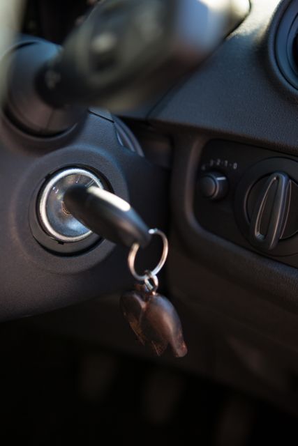 This image shows a close-up view of a car ignition with a key inserted in the dashboard. Ideal for use in articles or advertisements related to car security, vehicle maintenance, driving tips, or automotive accessories. It can also be used in blogs or websites focusing on car reviews, driving safety, or automotive technology.