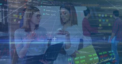 Businesswomen Analyzing Stock Markets on Laptop in Office