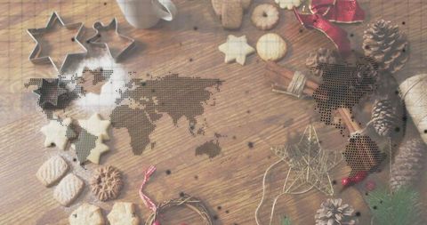 Festive holiday baking flatlay with dotted world map overlay on rustic wooden table