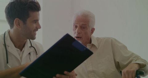 Doctor consulting with elderly patient in clinic room