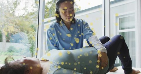 Hands-on abdominal assessment by clinician in bright clinic promoting physiotherapy rehab