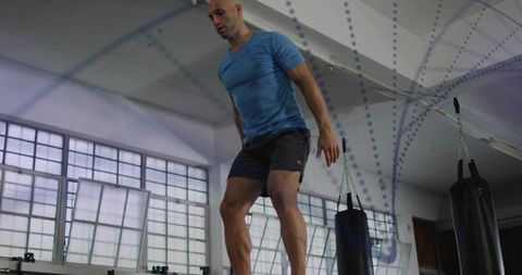 Man jumping in boxing gym doing plyometric cardio training for athletic performance
