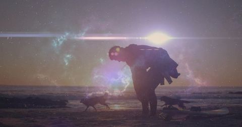 Surfer carrying gear on sunset beach with dogs, nebula sky and lens flare silhouette