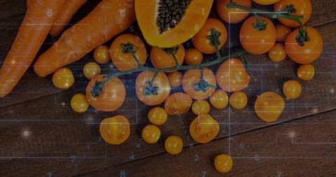 Amber Cherry Tomatoes on Vine with Halved Papaya Seeds and Carrots on Rustic Wooden Board