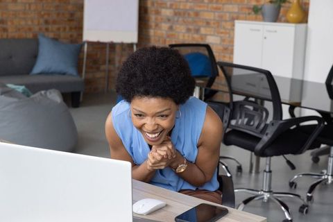 Enthusiastic professional on laptop in modern workspace
