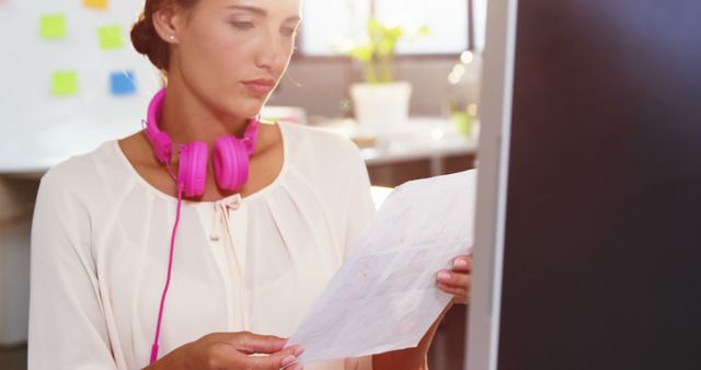 Focused Female Designer Reviewing Design Blueprints in Office - Download Free Stock Images Pikwizard.com