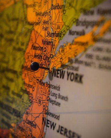 Pushpin marking new york metropolitan area on vintage map close-up with shallow depth
