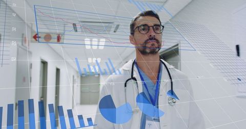 Male Doctor Analyzing Digital Data Charts in Hospital Corridor