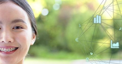 Smiling asian woman wearing metal braces with digital finance network overlay