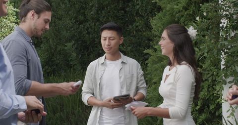 Friends socializing outdoors with digital devices