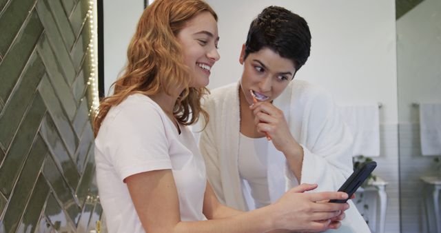 Smiling Friends Using Smartphone in Bathroom While Brushing Teeth - Download Free Stock Images Pikwizard.com