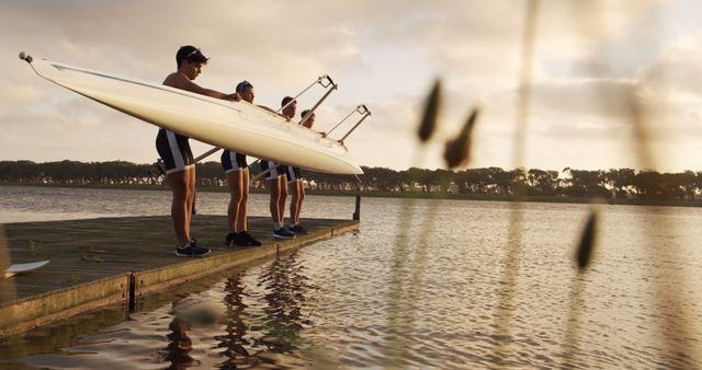 Four Athletes Preparing Rowing Boat on Lake Dock at Sunrise - Download Free Stock Images Pikwizard.com