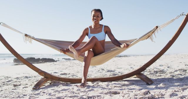 African american woman sitting on a hammock at the beach. travel romantic vacation lifestyle concept