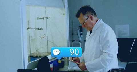 Researcher consulting tablet beside fume hood with lab glassware and notification overlay