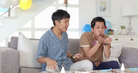 Two Friends Celebrating with Confetti and Party Hats Indoors