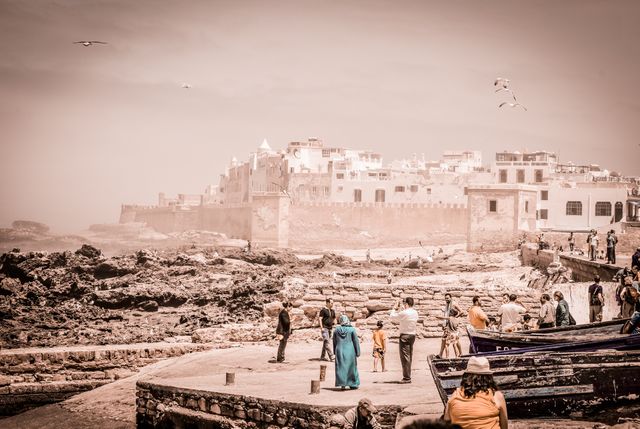 Tourists and Locals Strolling Near Ancient Coastal Town - Download Free Stock Images Pikwizard.com