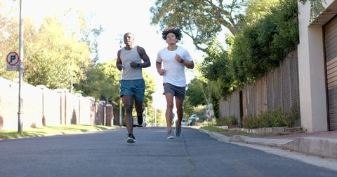 Two male runners exercising on a suburban street