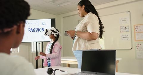 African american teacher guiding young girl wearing vr headset for immersive stem learning