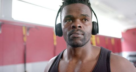 Determined Man Wearing Headphones Focusing on Workout at Gym