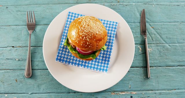 Delicious Burger on White Plate with Blue Napkin Garnish - Download Free Stock Images Pikwizard.com