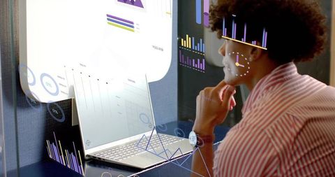 Focused Analyst Analyzing Augmented Reality Data Dashboards on Laptop in Modern Workspace