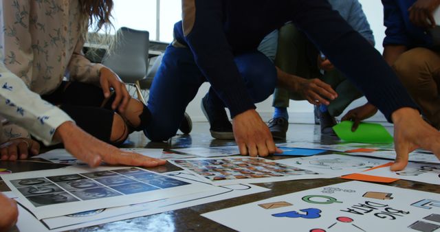 Group of individuals brainstorming and collaborating on project ideas. Suitable for illustrating teamwork, creative process, collaboration in an office setting, concept development, and design thinking workshops.