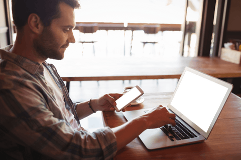 young man in cafe using laptop and mobile phone with transparent screens - Download Free Stock Videos Pikwizard.com