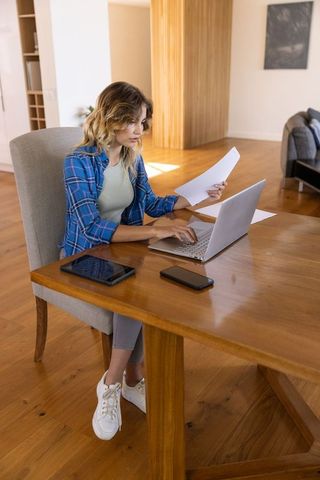 Focused Woman Working on Laptop in Minimalist Home Office