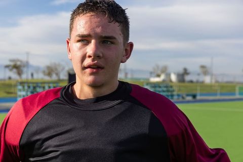 Focused teenage athlete on outdoor soccer field