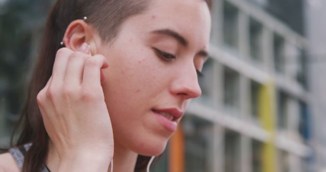 Woman Listening to Music with Earbuds in Urban Setting - Download Free Stock Images Pikwizard.com