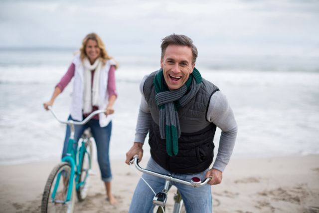 Portrait of mature couple riding bicycles on the beach 