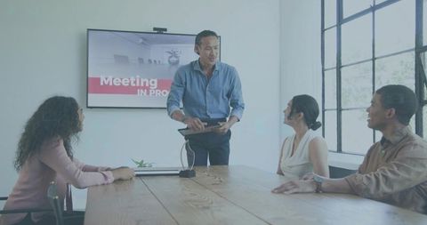 Leader presenting with tablet during collaborative boardroom meeting for team strategy