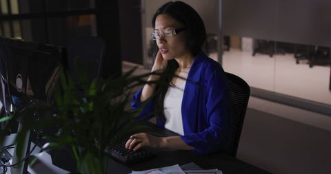 Tired Asian Businesswoman Working Late in Downtown Office