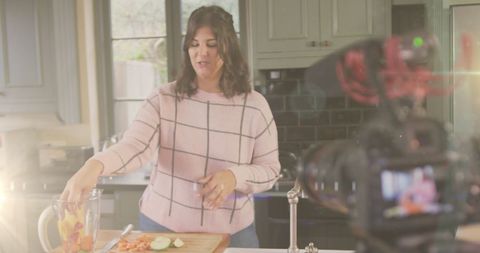 Female vlogger recording cooking tutorial at home