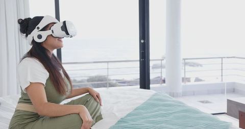Woman Enjoying Virtual Experience on Bedroom Amid Ocean View
