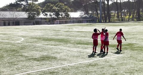 Youth Soccer Players Celebrating on Field in Team Jerseys