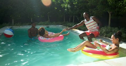 Diverse Friends Enjoy Summer Fun and Relaxation in Backyard Pool
