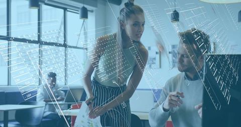 Young professionals collaborating with holographic analytics in modern open office