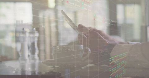Hands holding smartphone over coffee with financial charts overlay, mobile trading