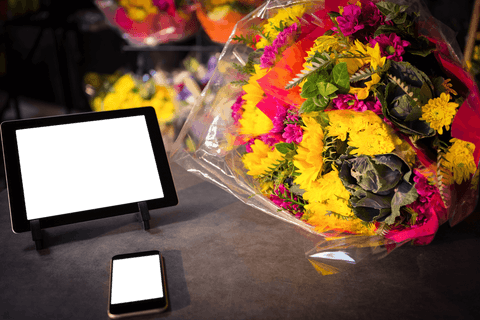 Vibrant Flower Bouquet with Modern Transparent Gadgets on Table