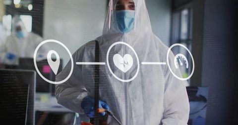 Disinfection technician wearing full ppe spraying office glass with health tracking icons