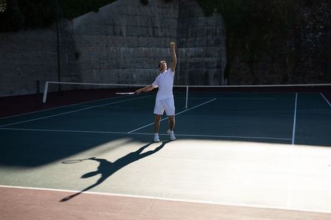 Male Tennis Player Serving in Action on Outdoor Court