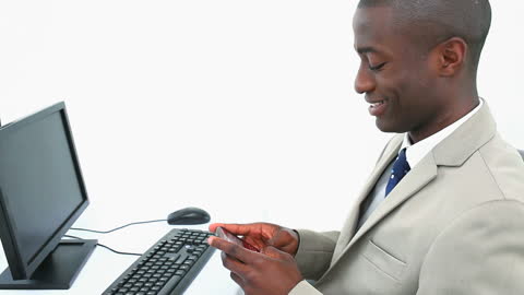 Businessman Smiling While Texting at Desk