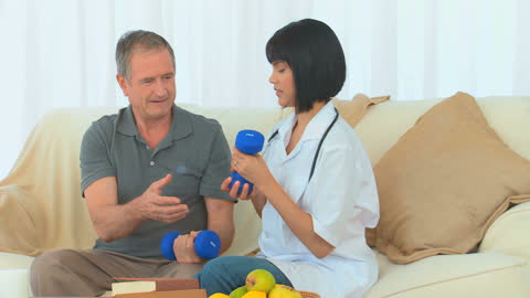 Nurse Assisting Older Man with Dumbbell Exercise Routine