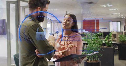 Young professionals discussing cybersecurity with AR interface in modern office workspace
